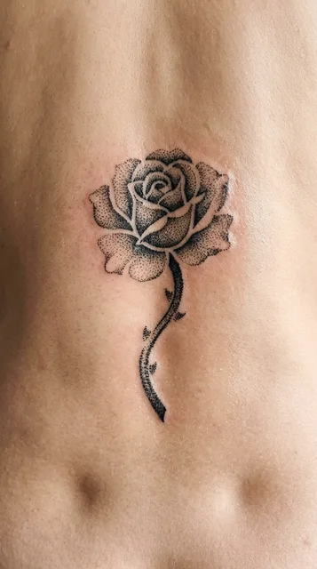 Black and grey dotwork tattoo on a woman's back