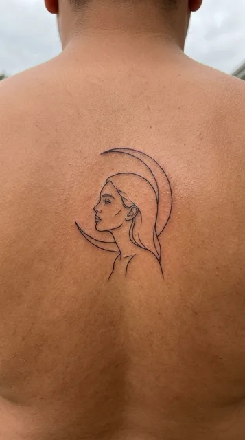 Black and white fine line woman portrait tattoo on a man's back