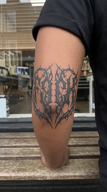 Black and white blackwork ornament tattoo on a woman's elbow