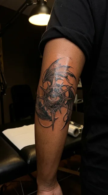 Black and grey dotwork eye tattoo on a woman's elbow