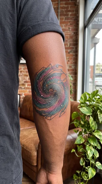Color illustrative galaxy tattoo on a man's elbow