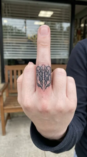 Black and white blackwork ornament tattoo on a woman's finger