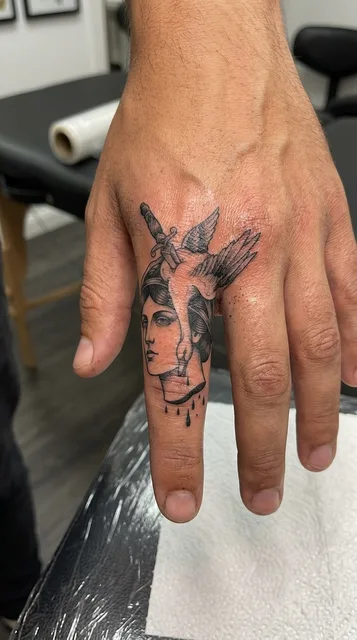 Black and grey dotwork woman tattoo on a man's finger
