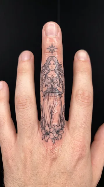 Black and grey illustrative woman tattoo on a man's finger