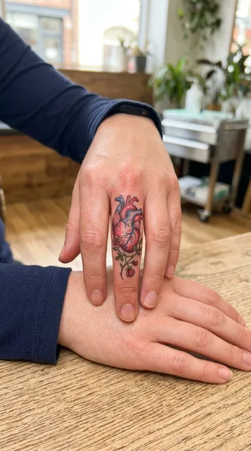 Color illustrative heart tattoo on a woman's finger