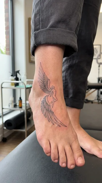 Black and white fine line angel tattoo on a woman's foot
