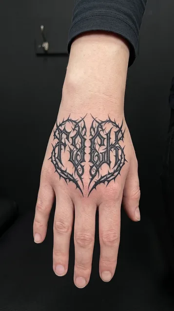 Black and white blackwork ornament tattoo on a woman's hand