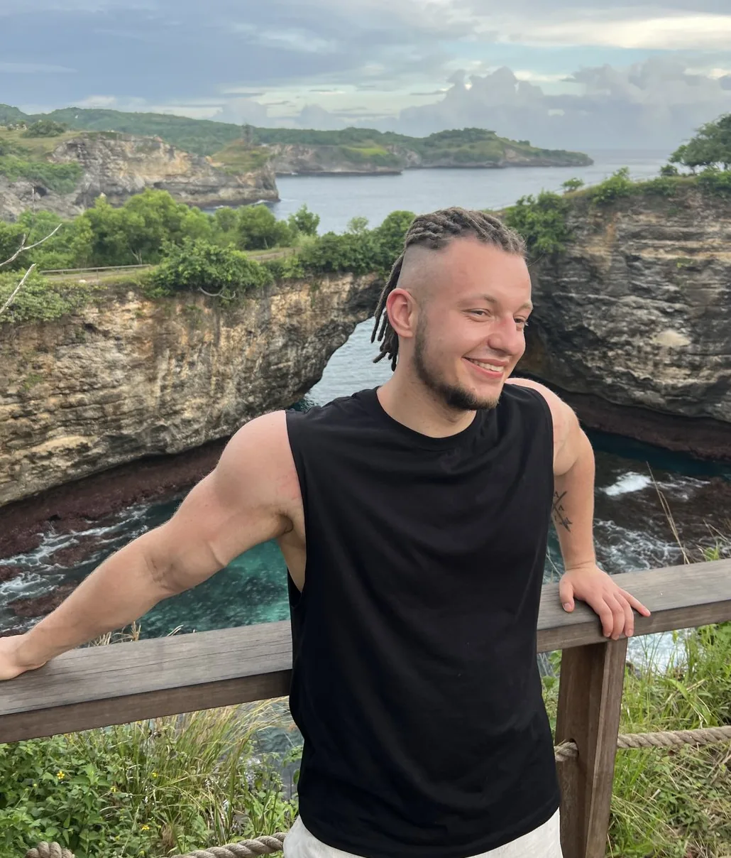 One of the try-on sample photos: a man in a black sleeveless top on a clifftop, no tattoo on his neck